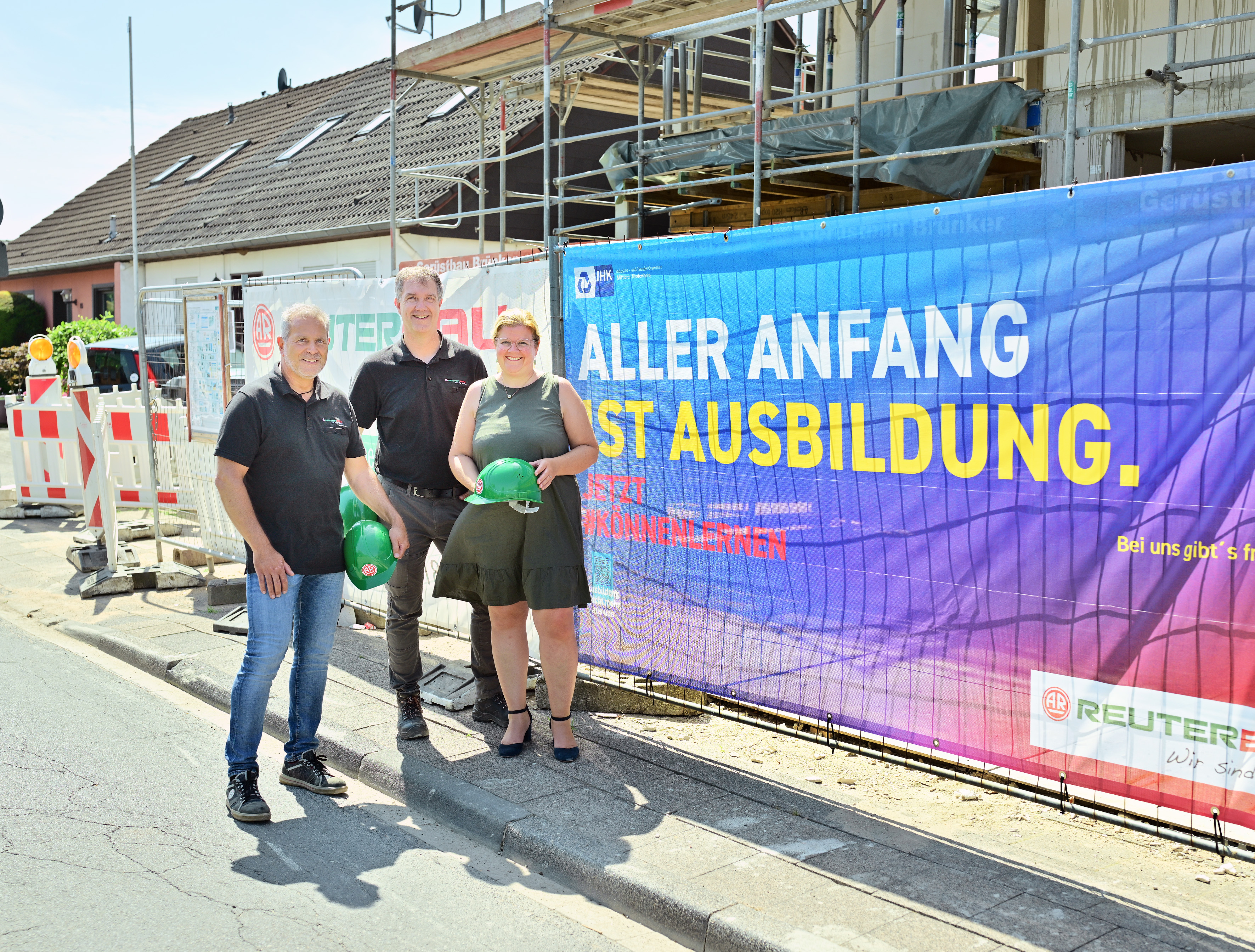 Mit der Werbebanner-Kampagne unterstützt die IHK Unternehmen und insbesondere Ausbildungsbetriebe dabei, auf ihre Ausbildungsangebote aufmerksam zu machen. Im Falle der Reuter Bauunternehmen GmbH ist das Banner an einem Bauzaun befestigt worden –  im Beisein von Geschäftsführer Mario Prömpers (l.), dem technischen Leiter Bernd Wirtz und IHK-Geschäftsführerin Daniela Perner.