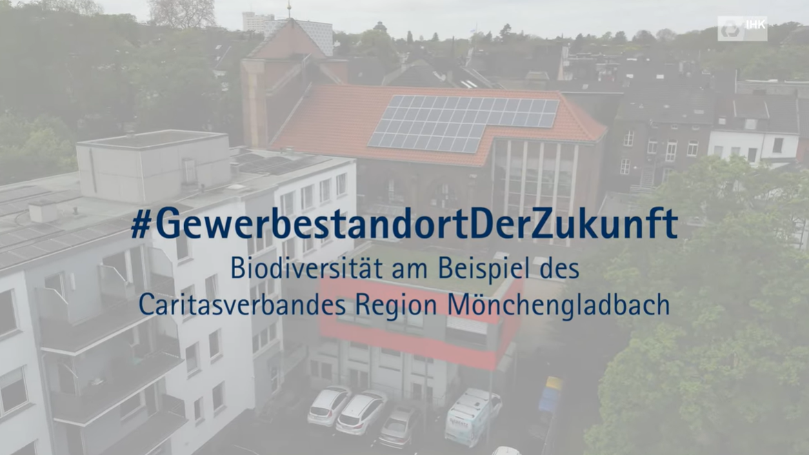 Luftaufnahme eines Gebäudekomplexes mit Solaranlage auf dem Dach, überlagert mit dem Text „#GewerbestandortDerZukunft – Biodiversität am Beispiel des Caritasverbandes Region Mönchengladbach“.