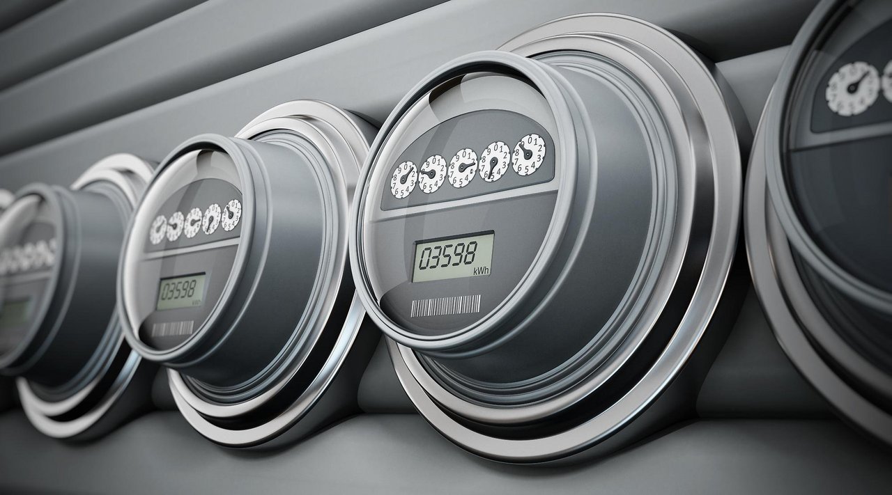 Mehrere moderne digitale Stromzähler sind nebeneinander an einer Wand montiert. Ein Zähler im Vordergrund zeigt einen aktuellen Stromverbrauch von 03598 Kilowattstunden (kWh) an.