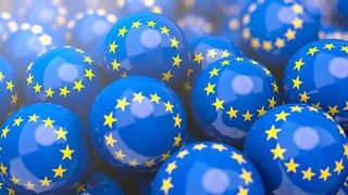 Mehrere glänzende blaue Kugeln mit gelben Sternenkreisen, die die Europaflagge darstellen.