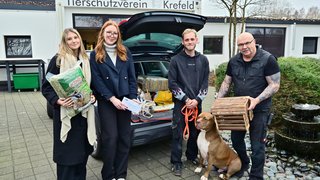 Die IHK-Auszubildende Ina Intveen und Lea-Charlotte Hoffmann haben die Spenden an Tierheim-Mitarbeiter Alex Manthey und Tierheimleiter Frank Schankat überreicht (v.l.n.r.). Mit dabei war auch Hund Chico.