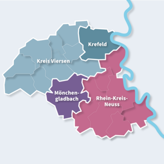 Karte des IHK-Bezirks mit farblich abgesetzten Bereichen: Kreis Viersen (blau), Krefeld (dunkelblau), Mönchengladbach (gelb) und Rhein-Kreis Neuss (lila). Der Rhein verläuft geschwungen durch das Gebiet. Die Regionen sind weiß umrandet und mit weißer Schrift beschriftet.