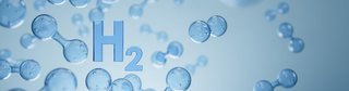 Darstellung mehrerer transparenter Wasserstoffmoleküle (H₂) in blauer Farbe vor einem hellblauen Hintergrund, mit einem zentral platzierten „H₂“-Schriftzug in 3D-Optik.