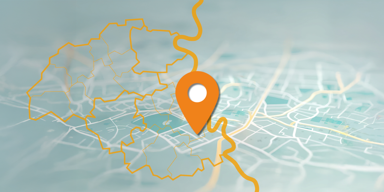 Eine stilisierte Karte mit einem orangefarbenen Standortmarker in der Mitte. Die Karte zeigt ein Straßennetz und eine gelbe, unregelmäßige Umrisslinie, die den IHK-Bezirk Mittlerer Niederrhein darstellt.kiert.