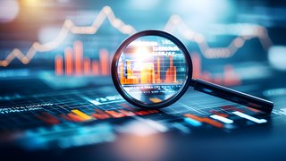 Vergrößerungsglas über einem digitalen Finanzdiagramm mit Balken- und Liniendiagrammen, das bestimmte Daten hervorhebt.