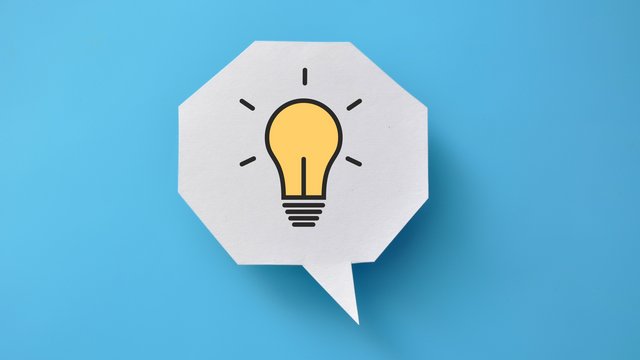 Illustration einer gelben Glühbirne in einer weißen Sprechblase auf blauem Hintergrund, symbolisiert eine Idee oder Inspiration.